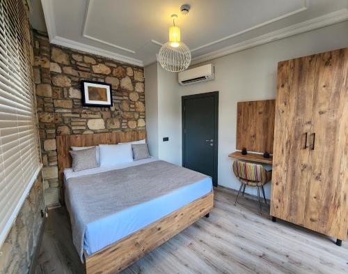 a bedroom with a bed and a stone wall at Sera Homes Kaleici Oldtown in Antalya