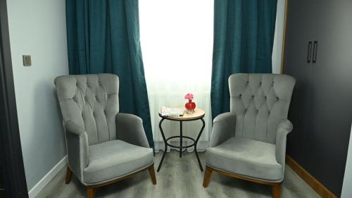 two chairs and a table in a room with a window at Asgard Hotel in Beylikduzu