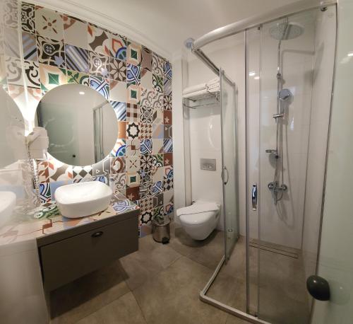 a bathroom with a shower and a toilet and a mirror at Sera Homes Kaleici Oldtown in Antalya