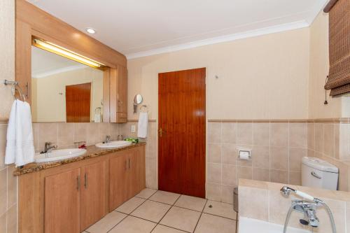 ein Badezimmer mit zwei Waschbecken und einer Holztür in der Unterkunft Kruger Park Lodge Unit No 441 with Private Pool in Hazyview