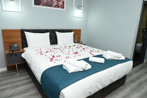 a bedroom with a large bed with red flowers on it at Asgard Hotel in Beylikduzu
