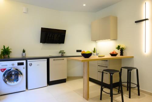 a kitchen with a washing machine and a table with stools at Majestic View Villas in Agios Nikolaos