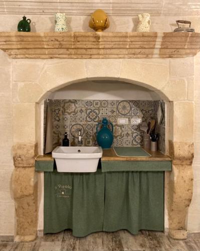 a kitchen with a sink in a stone oven at Il Vicolo Grottaglie in Grottaglie