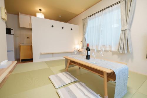 Sala de estar con mesa y botella de vino en 匯家•平和島ビル en Tokio