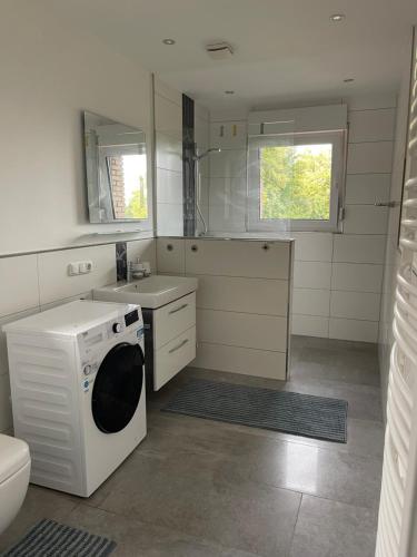 een keuken met een wasmachine en een wastafel bij Monteurzimmer in Porta Westfalica