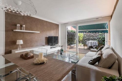un soggiorno con divano e tavolo di Chalet independiente de diseño con Patio Privado a Madrid
