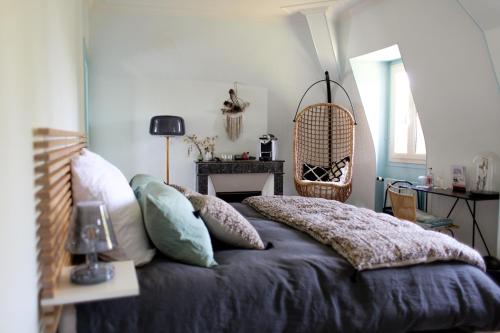 a bedroom with a bed with pillows on it at Le Clos des Fées in Asnières-sur-Oise