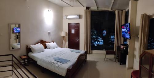 um quarto com uma cama e uma televisão de ecrã plano em The Sunshine Bungalow em Bangalore