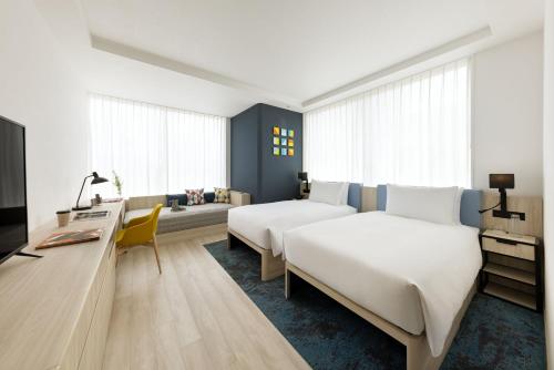 東京にあるハイアット ハウス 東京 渋谷のベッド2台とソファが備わるホテルルームです。