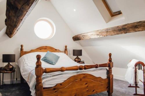 a bedroom with a wooden bed in a attic at 'The Dairy' - Nestled in a traditional farmyard. in Stourbridge