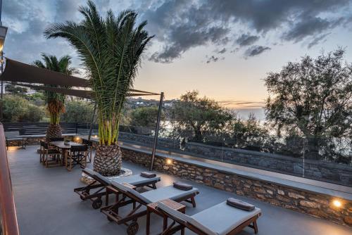 eine Terrasse mit Tischen und Stühlen und Meerblick in der Unterkunft Aniv Villa by the Sea in Kini