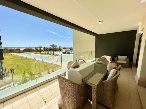 OCEAN HOMES Apartamentos exclusivos en Isla Canela by AC REAL في إيسلا كانيلا: غرفة طعام مع طاولة وكراسي ونافذة كبيرة
