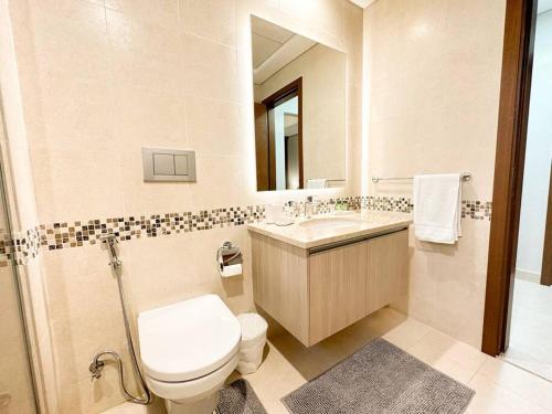 a bathroom with a toilet and a sink and a mirror at On-The-Go Golf 202B3 in Abu Dhabi
