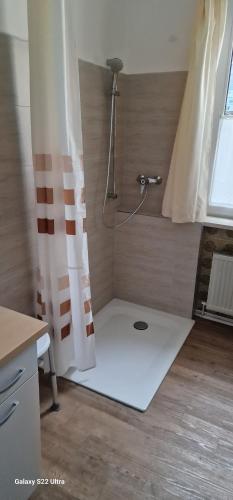 a bathroom with a shower with a shower curtain at Gästehaus Rogner in Goslar