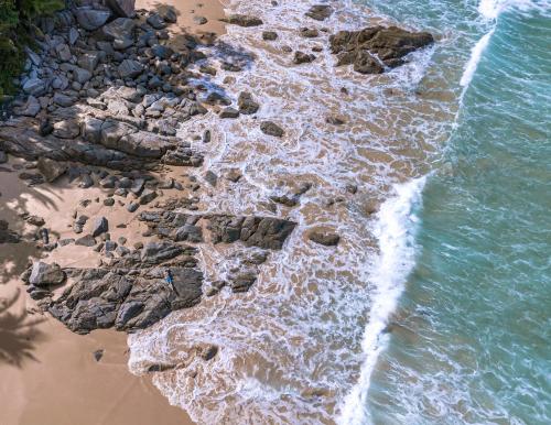 an aerial view of the shoreline of a rocky beach at Sealord Naithon Beachfront Villa in Nai Thon Beach