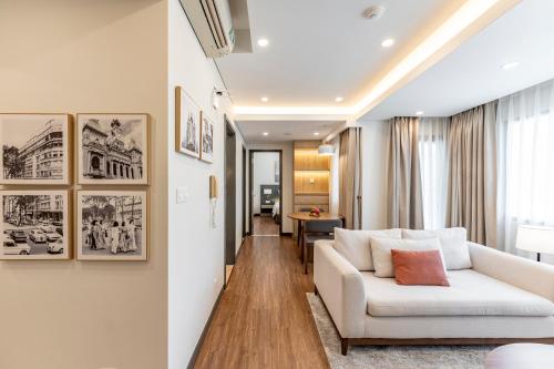 Garden View Court Suites Ho Chi Minh City في مدينة هوشي منه: غرفة معيشة مع أريكة بيضاء وطاولة