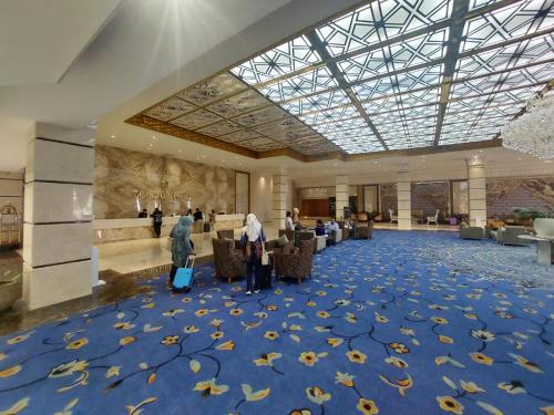 un vestíbulo con una alfombra azul con hojas. en Grand Qin Hotel Banjarbaru, en Banjarbaru