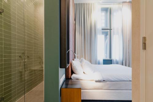 a hotel room with a bed and a shower at Hotel De Hallen in Amsterdam