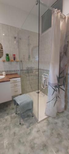 baño con ducha con taburete y banco en gîte Aux Tourterelles, en Tournemire
