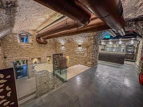 a large room with a stone wall and pipes at Chateau Mephis Kalaki in Akhalkʼalakʼi