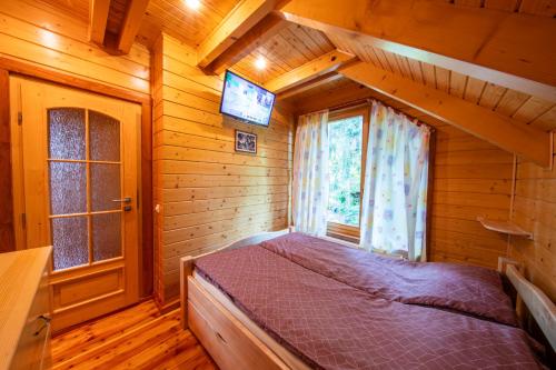 a bedroom with a bed in a wooden house at Forest Home Relax in Borzont