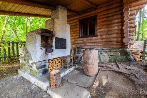 an outdoor oven in the side of a log cabin at Forest Home Relax in Borzont