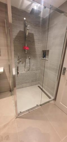 a shower with a red umbrella in a bathroom at Ballymena/ Belfast/ Antrim Coast/Galgorm in Ballymena