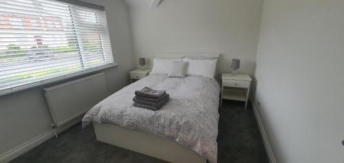 a white bedroom with a bed with two night stands at Ballymena/ Belfast/ Antrim Coast/Galgorm in Ballymena