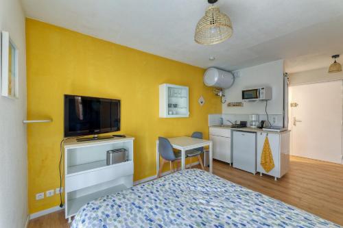 1 dormitorio con 1 cama y cocina pequeña en Charmant studio à 5 minutes de la mer à pied en Saint-Nazaire