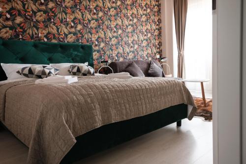 una camera con letto e testiera verde di KONSTANZER Q-Residence a Iaşi