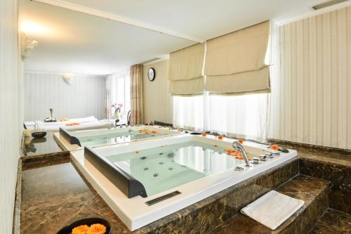 a large bathroom with a large bath tub at Hotel Grand Saigon in Ho Chi Minh City