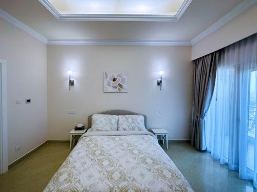 I Like Al Hamra Palace - Elite Beach & Golf Resort Private Suites في رأس الخيمة: غرفة نوم بسرير كبير في غرفة
