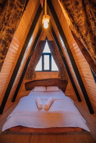 a bed in a wooden room with a window at KARMATTE BUNGALOW in Kartepe