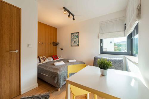Kleines Zimmer mit einem Bett und einem Tisch in der Unterkunft Apartament Olimpijska 26 - 200 m od wyciągu - Dream Apart in Szczyrk