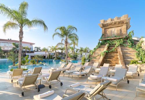 een groep stoelen en een zwembad in een resort bij Olympic Lagoon Resort Paphos in Paphos City