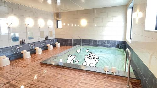 un baño con una piscina con animales de dibujos animados. en Sabae Daiichi Hotel en Sabae