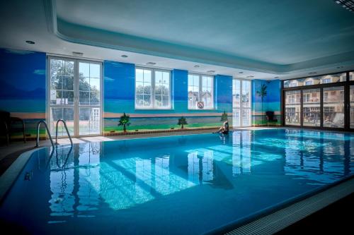 a large swimming pool with a person in the middle at Hotel Verde in Koszalin