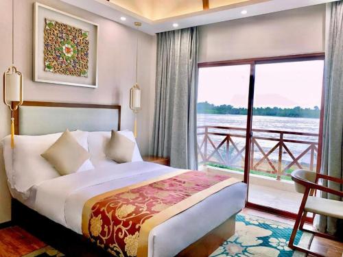 a bedroom with a bed and a large window at MonMonBoutique Hotel in Thakho