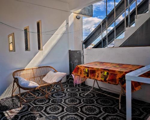 a table and a chair in a room with stairs at Port Louis Centre penthouse in Port Louis