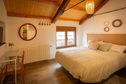 a bedroom with a bed and a table and a mirror at Refugio de los Sueños in Valdeganga