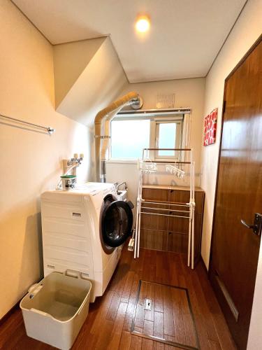 a bathroom with a washing machine in a room at Kitanoya Furano in Furano