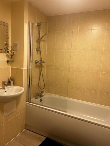 a bathroom with a shower and a tub and a sink at Stylish 2 bedroom Apartment-Short term lets & Serviced Accomodation Reading in Reading