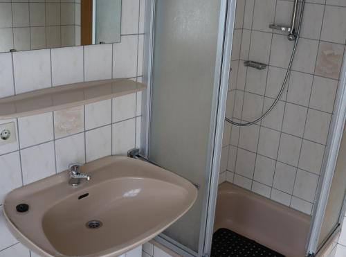 uma casa de banho com um lavatório e um chuveiro em Ferienwohnung Krabbenkutter em Werdum