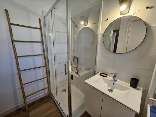 ein Bad mit einem Waschbecken und einer Dusche mit einem Spiegel in der Unterkunft Cosy Cottage -Vue Pyrénées- T5 - Piscine - 8 pers 
