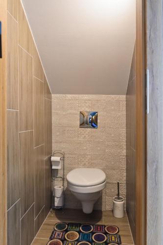 a small bathroom with a toilet and a rug at Boutique apartmán in Krompachy