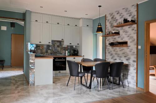 a kitchen and dining room with a table and chairs at Boutique apartmán in Krompachy