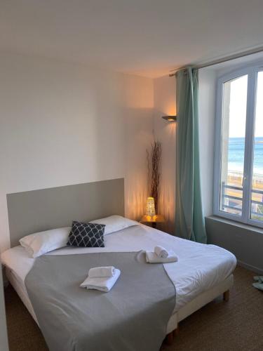 a bedroom with a bed with towels on it at Le Château de Sable in Plougasnou