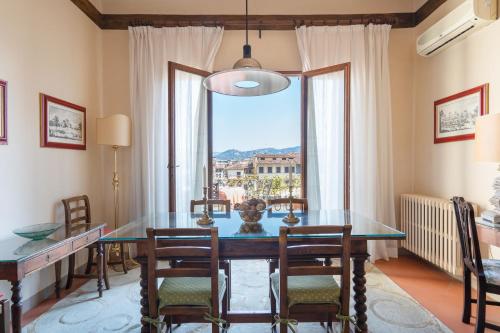 a dining room with a table and chairs and a window at Palazzo Antellesi in Florence
