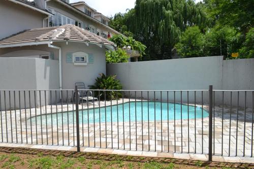 a fence around a swimming pool in front of a house at Lonehill - Standard 2 Guest Studio Suite 2 in Sandton