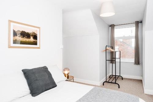 a white bedroom with a bed and a window at Alice's Central Stay: Parking + Close to the Motor Point Arena in Nottingham